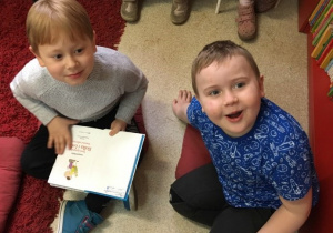 Dwóch chłopców przegląda książkę.